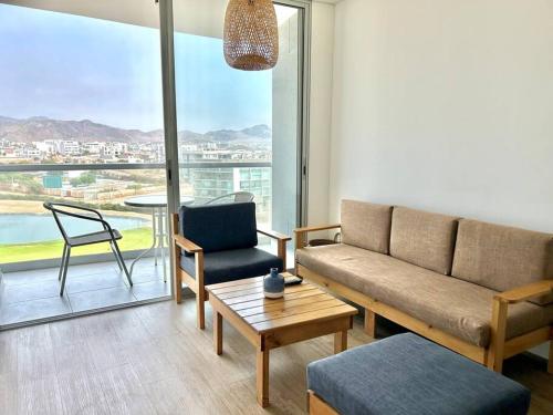 sala de estar con sofá, silla y mesa en Departamento de playa con piscina, en San Bartolo