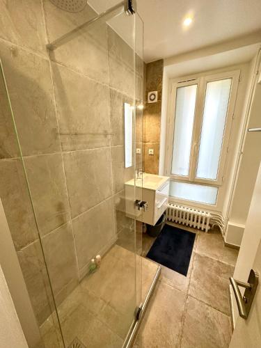 a bathroom with a shower and a sink and a window at Elegant Paris Pantin apartment - line 7 in Pantin