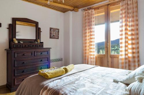 a bedroom with a dresser and a mirror and a bed at Casa Beatriz Valdelinares in Valdelinares