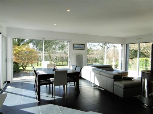 un salon avec une table et un canapé dans l'établissement Maison 5 pièces 8 personnes avec jardin clos à proximité de la mer - ERELL, à Sarzeau