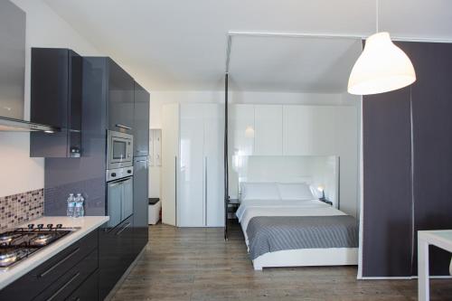 a bedroom with a bed and a kitchen with a stove at San Siro's Lights in Milan