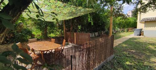 una valla con mesa y sillas en un patio en Terracotta-T2-Clim-Parking gratuit privé, en Pierre-Bénite