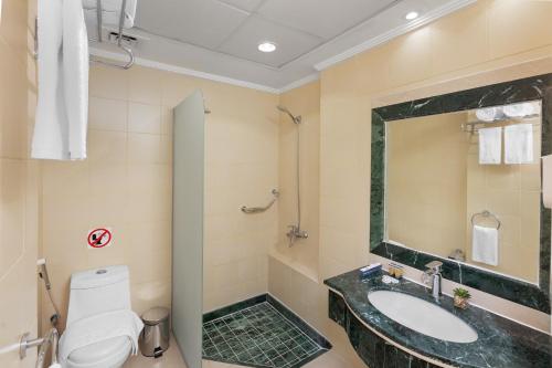 a bathroom with a sink and a toilet at Ewan Dar Alhejra Hotel in Al Madinah