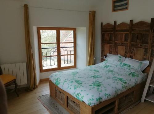 Schlafzimmer mit einem Bett und einem Fenster in der Unterkunft Maison de campagne dans Parc National de Forêts in Rochetaillée-sur-Aujon