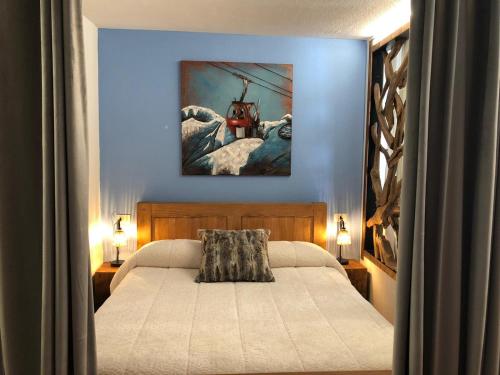 1 dormitorio con 1 cama y una pintura en la pared en Cervinia – Matterhorn Apartments, en Breuil-Cervinia