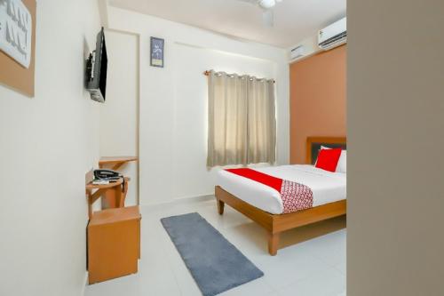 a bedroom with a bed and a television in it at 79522 The Host in Bangalore