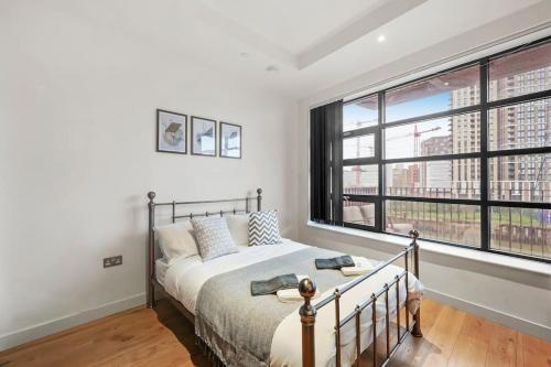 a bedroom with a bed and a large window at Livestay-Studio Apartment in Modern Development in London