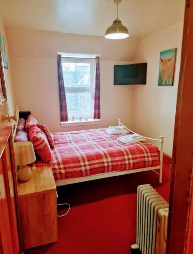 a small bedroom with a bed and a window at Ness City Apartment in Inverness