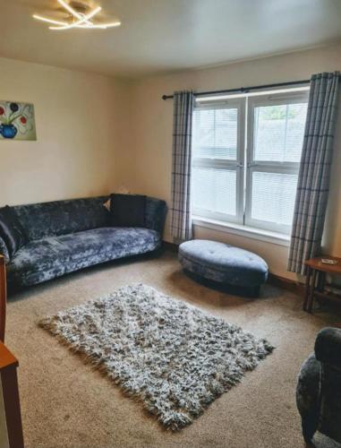 a living room with a couch and a window at Ness City Apartment in Inverness