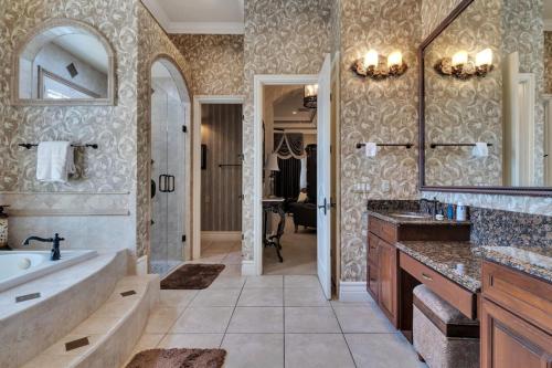 a bathroom with a tub and a sink and a mirror at Luxury 5 bed 5.5 bath Villa close to everything in Kissimmee