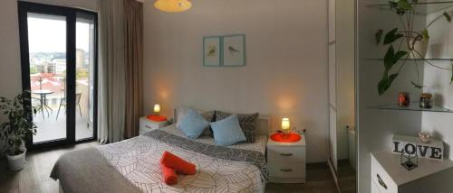 a bedroom with a bed with orange pillows on it at Ameri Plaza Green Apartments in Tbilisi City