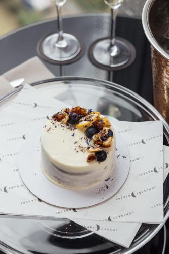 a dessert on a plate on a table with wine glasses at Montcalm Royal London House, London City in London