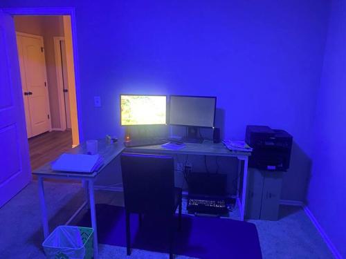a blue room with a desk with a computer on it at Cheerful 3 Bdrm space, 2 bath!. You gotta love it! in Oklahoma City