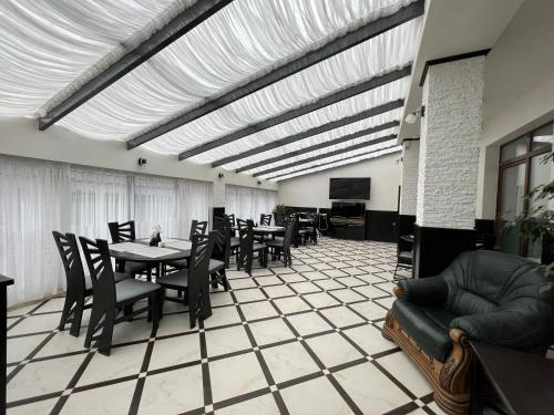 ein Esszimmer mit Tischen und Stühlen sowie einem TV in der Unterkunft Villa For You Hotel in Poljanyzja