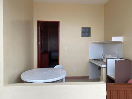 a small kitchen with a table and a sink at Kellocks' Seaview Apartelle in Dalaguete