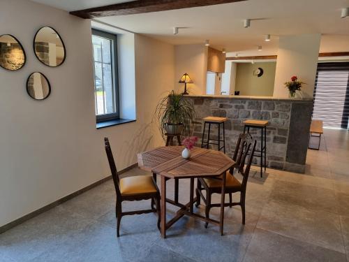 uma sala de jantar com uma mesa de madeira e cadeiras em Grand gîte du Moulin de Bourges em Momignies