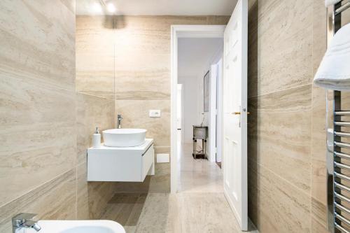 een badkamer met een witte wastafel en een toilet bij Appartamento luminoso di design in centro in Cagliari