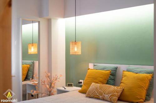 sypialnia z łóżkiem z żółtymi poduszkami i lustrem w obiekcie roomaki -tasteful studio in the center w/ parking w Chalkidzie