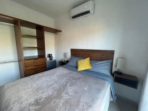 a bedroom with a bed with a yellow pillow at Casa Spa Palmeras - Habitación Privada in Cancún