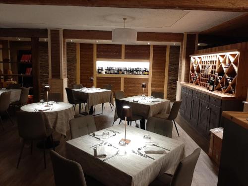 a restaurant with tables and chairs and a bar at Hotel Valle Pesio Ristorante in Chiusa di Pesio