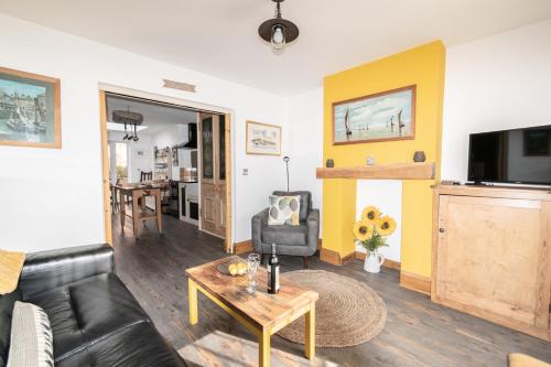 a living room with a couch and a table at 2-Bedroom Stylish, Cosy & Bright Cottage, Pet Friendly, Sleeps 5, Titchfield Village - by Blue Puffin Stays in Titchfield