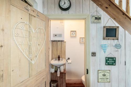 a bathroom with a heart on the wall and a sink at 2 BR Stylish Bright Cottage, Pet Friendly - Titchfield Village by Blue Puffin Stays in Titchfield