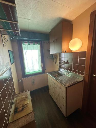 a small kitchen with a sink and a window at Appartamenti Sud Ovest By MountainHouses in Sestriere