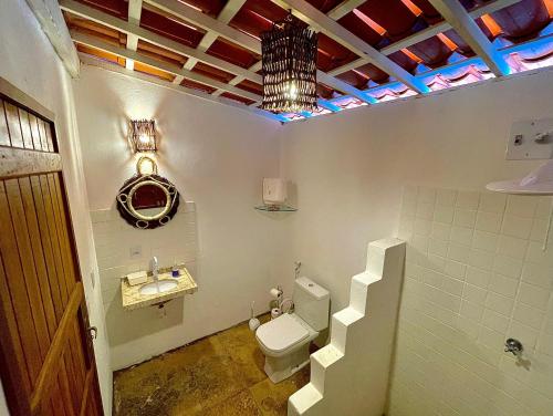 a bathroom with a toilet and a sink and stairs at Casa Ana Frank in Parajuru