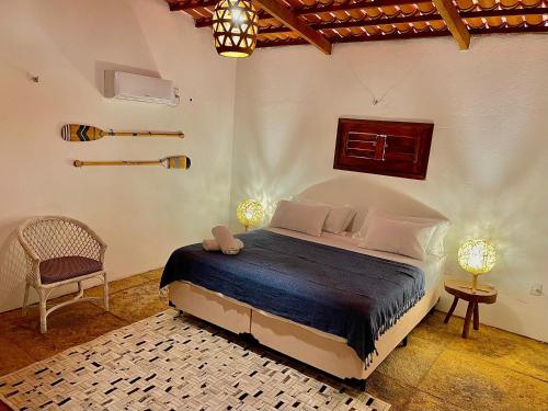 a bedroom with a bed and a chair in a room at Casa Ana Frank in Parajuru