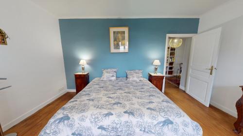 a bedroom with a bed with a blue wall at Les Terrisses - Chambres d'hôtes avec piscine in Saint-Félix-Lauragais