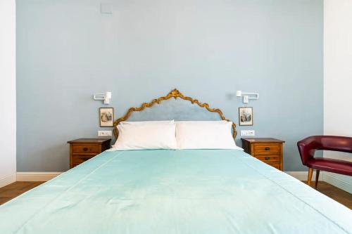 una camera con un letto blu e una sedia rossa di Appartamento luminoso di design in centro a Cagliari