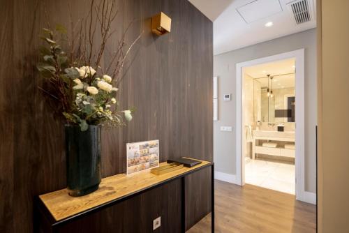 a vase of flowers on a table in a hallway at Chiado Mercy Apartments | Lisbon Best Apartments in Lisbon