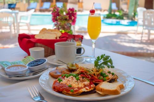 a table with a plate of food and a glass of orange juice at Tecnohotel Beach in San Benito