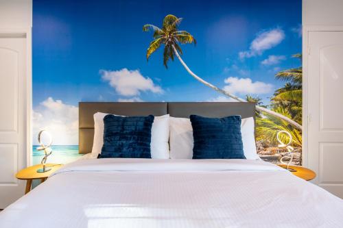 a bedroom with a bed with a palm tree mural at The Lauderdale Boutique Hotel in Fort Lauderdale