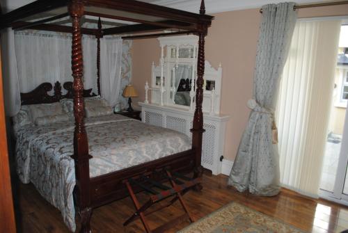 een slaapkamer met een hemelbed in een kamer bij Riverside Lodge in Carlingford