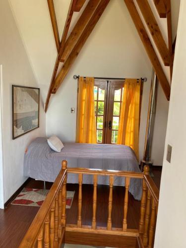 a bedroom with a bed and a window with yellow curtains at HOTEL BOUTIQUE CASA BLANCA in Chillán