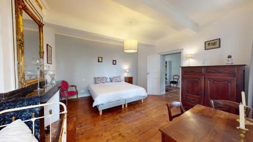 a bedroom with a bed and a table in a room at Les Terrisses - Chambres d'hôtes avec piscine in Saint-Félix-Lauragais