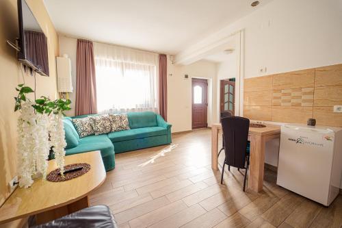 a living room with a green couch and a table at Hera's Garden in Arad