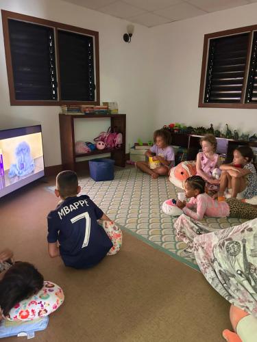 a group of children sitting on the floor in a room at The Phoenix Resort in San Pedro