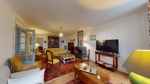 a living room with a couch and a television at Les Terrisses - Chambres d'hôtes avec piscine in Saint-Félix-Lauragais