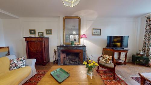 a living room with a fireplace and a mirror at Les Terrisses - Chambres d'hôtes avec piscine in Saint-Félix-Lauragais