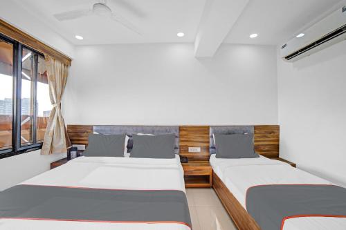 1 dormitorio con 2 camas y ventana en HOTEL TAPOVAN IN, en Ahmedabad