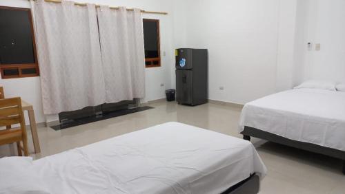 ein Schlafzimmer mit 2 Betten und einem TV in der Unterkunft EDIFICIO CUPIL in Puerto Baquerizo Moreno