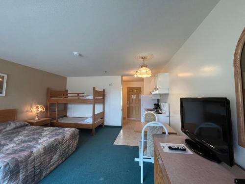 a hotel room with a bed and a flat screen tv at Western Budget Motel #3 Whitecourt in Whitecourt