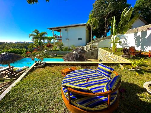 a backyard with a table and chairs next to a pool at Hotel Mahita Tsara in Djamandjary