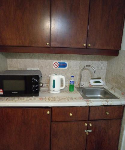 a kitchen counter with a microwave and a sink at Crown Apartment at Times Square in Kuala Lumpur
