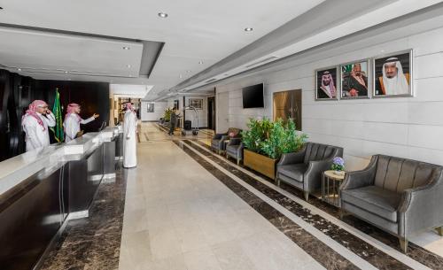 a hotel lobby with a bride and groom walking down the hallway at Ewan Dar Alhejra Hotel in Al Madinah