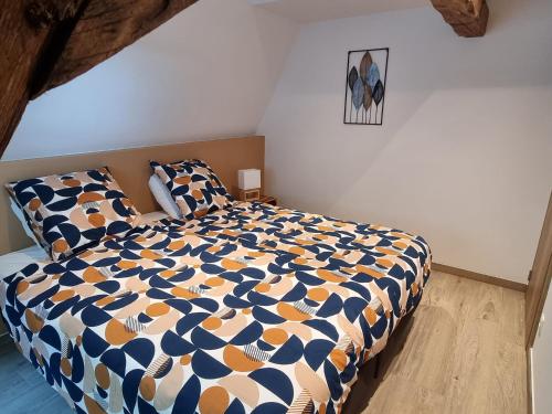 a bedroom with a bed with a blue and white comforter at Petit gîte du Moulin de Bourges in Momignies
