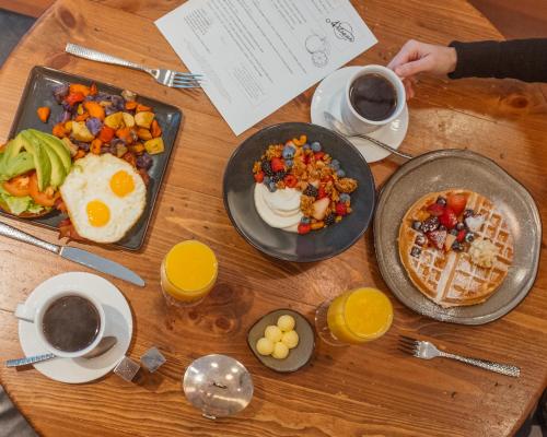 a wooden table topped with breakfast foods and coffee at The Ritz-Carlton, Boston in Boston