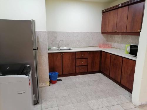a kitchen with wooden cabinets and a sink at Crown Apartment at Times Square in Kuala Lumpur